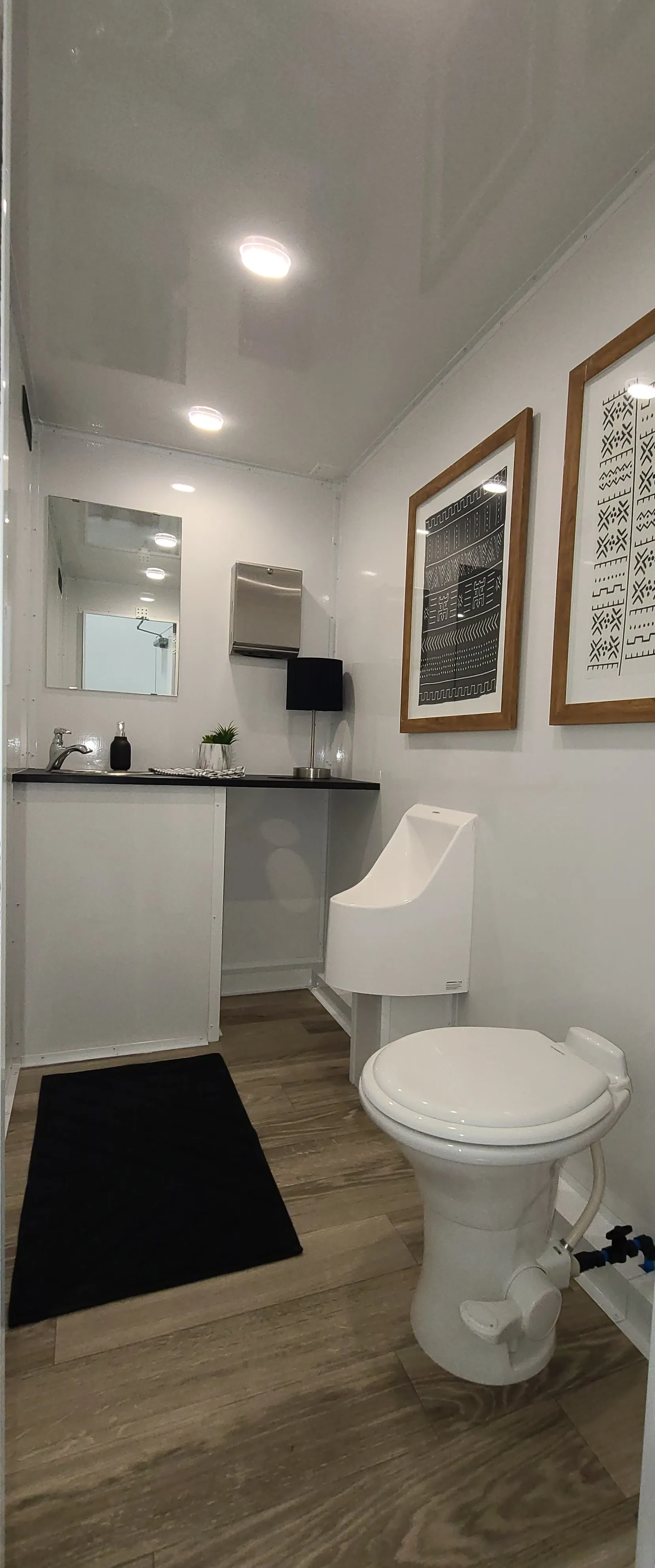 Men's restroom stall with flushing toilet, urinal, and hand washing station