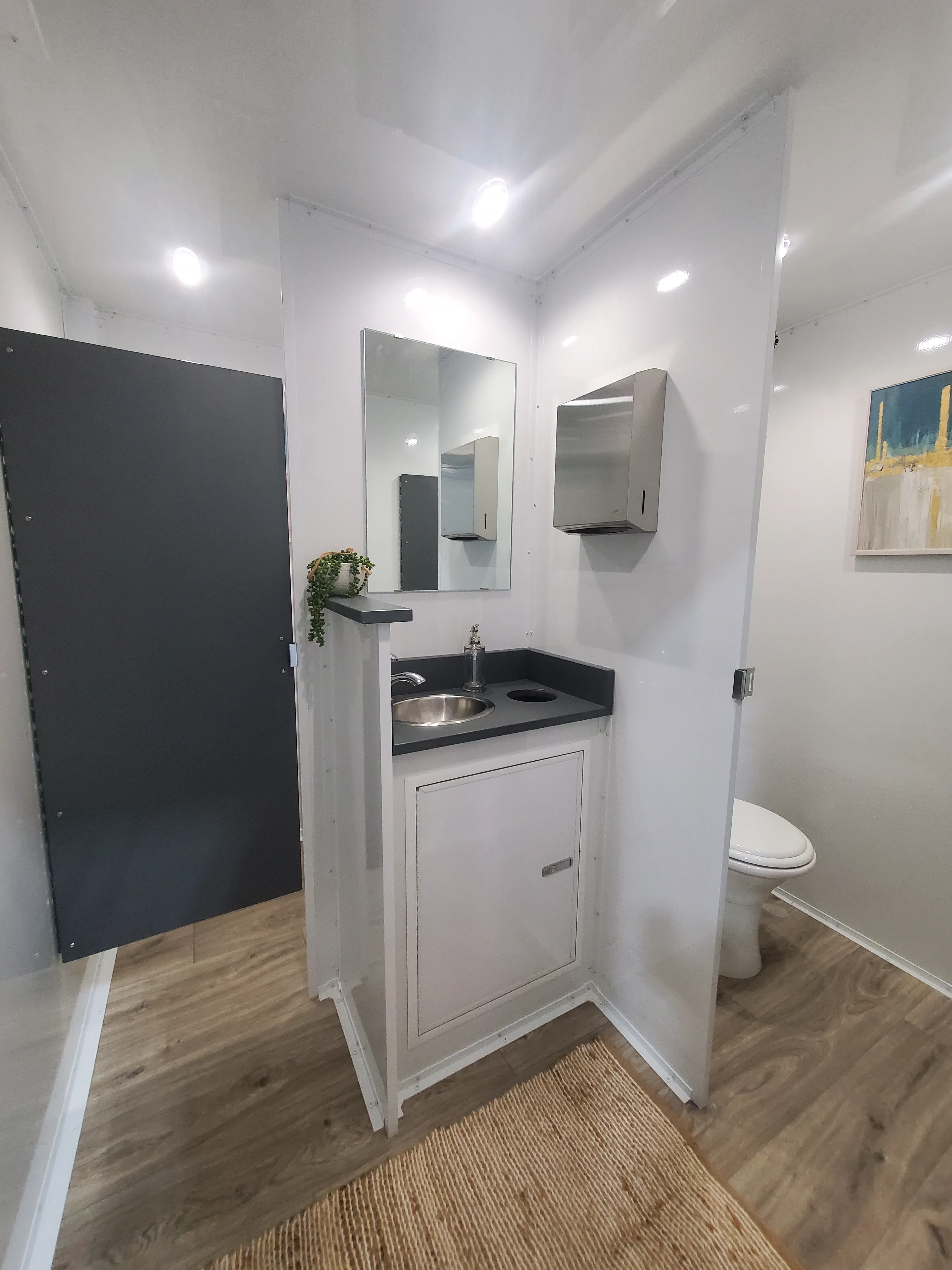 Women's restroom area with two spacious private stalls featuring flushing toilets and a shared vanity.