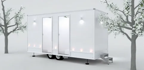 Luxury bathroom trailer rental for a wedding with three modern stalls and outdoor lighting.